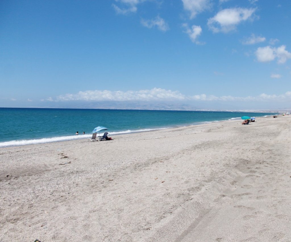Discover Cabo de Gata Spain: Mediterranean beach near the town of Cabo de Gata with a view in the distance of Almeria.